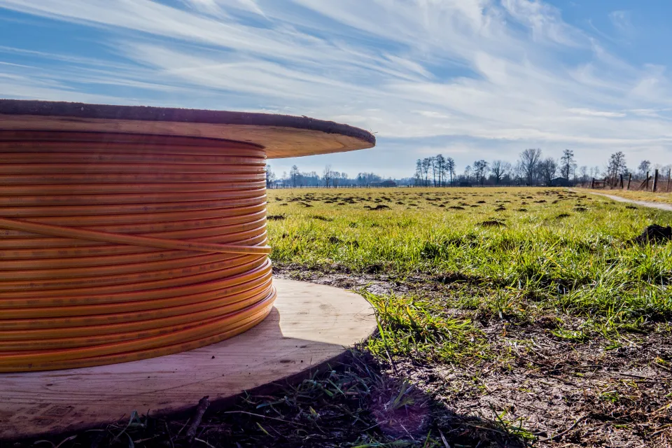 Close-up of spool of broadband internet wire sitting on the ground